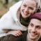 Young couple piggy back, smiling, looking away from camera