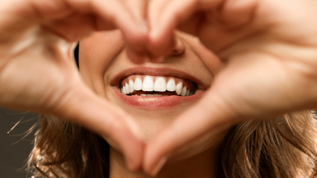 blog-pic Close up of woman's mouth with hands making heart shape